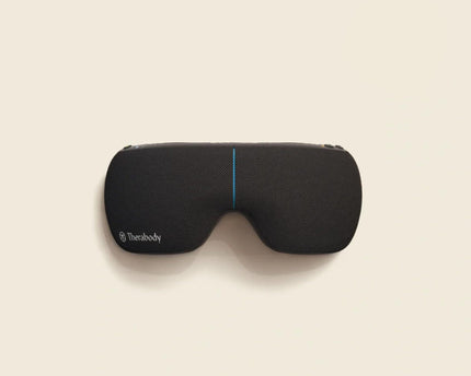 Black sleep mask with Therabody branding on a beige background